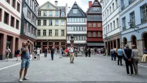 Menschen auf dem Hühnermarkt in der Frankfurter Altstadt, umgeben von restaurierten historischen Fachwerkhäusern