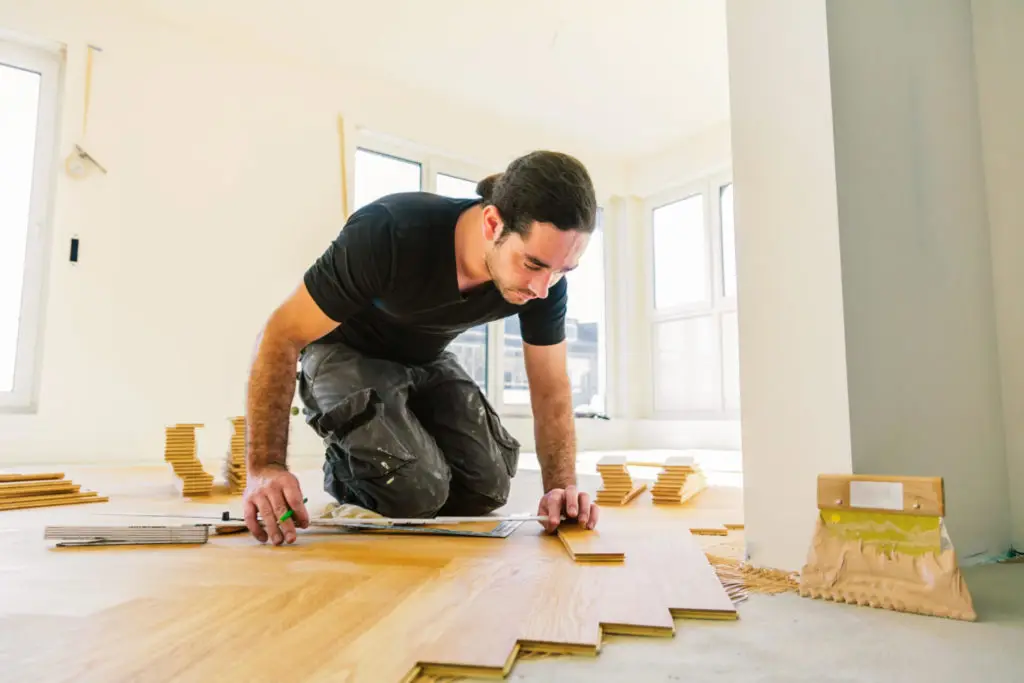 Fachmann verlegt Parkettboden in einer Wohnung in Frankfurt-Westend, um die Raumgestaltung mit edlem Holz zu vervollständigen.